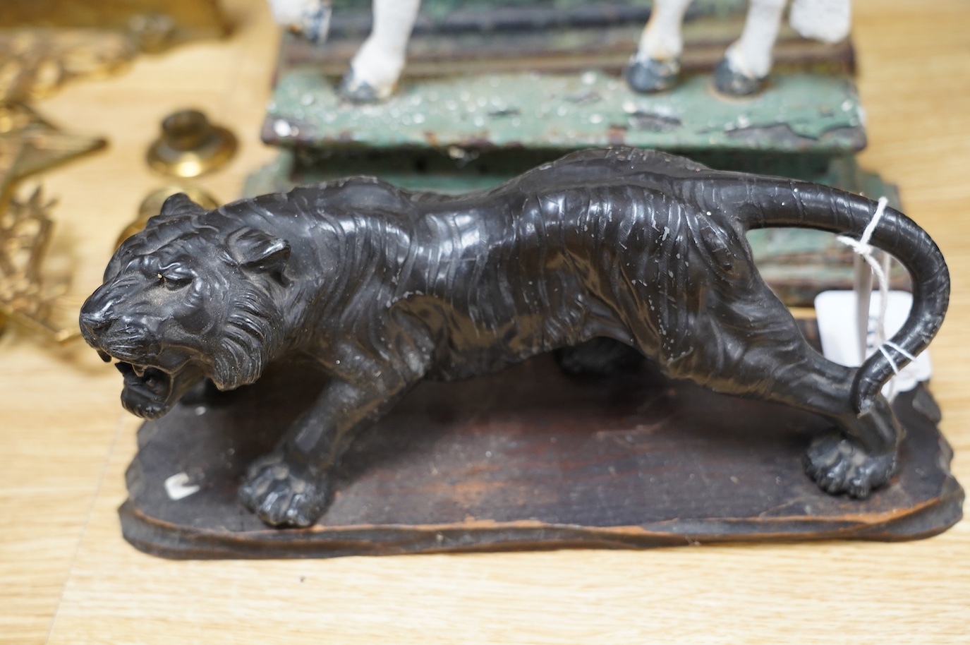 A Chinese spelter model of a tiger on hardwood plinth, a pair of Victorian painted cast iron ‘horse’ door-stops and a pair of brass two branch wall sconces, 37cm. Condition - fair